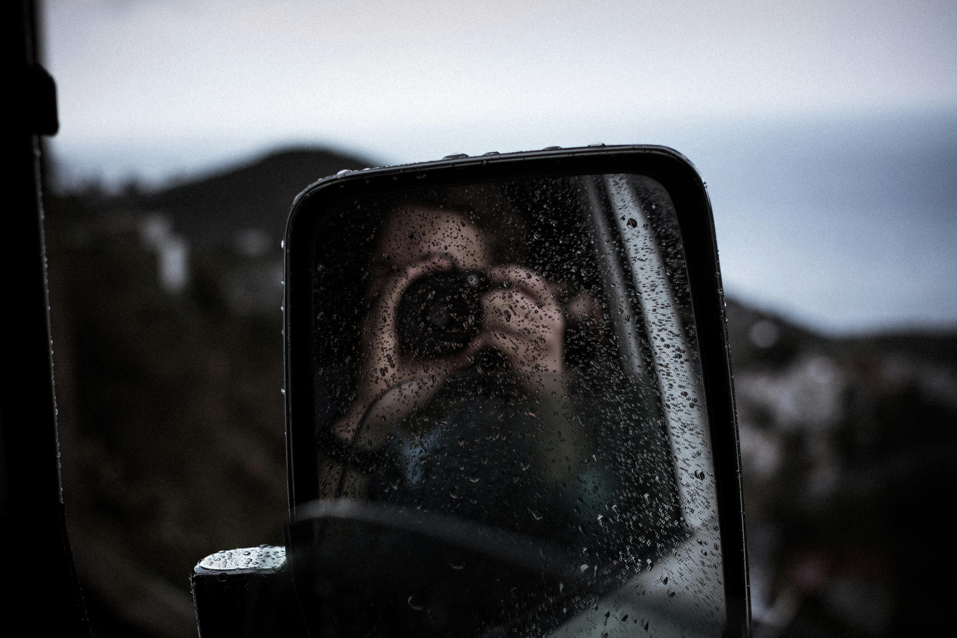 Photographing oneself in a rainy mirror.